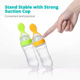 Baby feeding bottle being squeezed to dispense pureed food