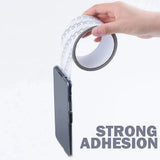 Window screen repair tape being applied over a torn screen